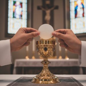 Le mani di un sacerdote sollevano l'ostia consacrata sopra un calice dorato durante la celebrazione della messa.